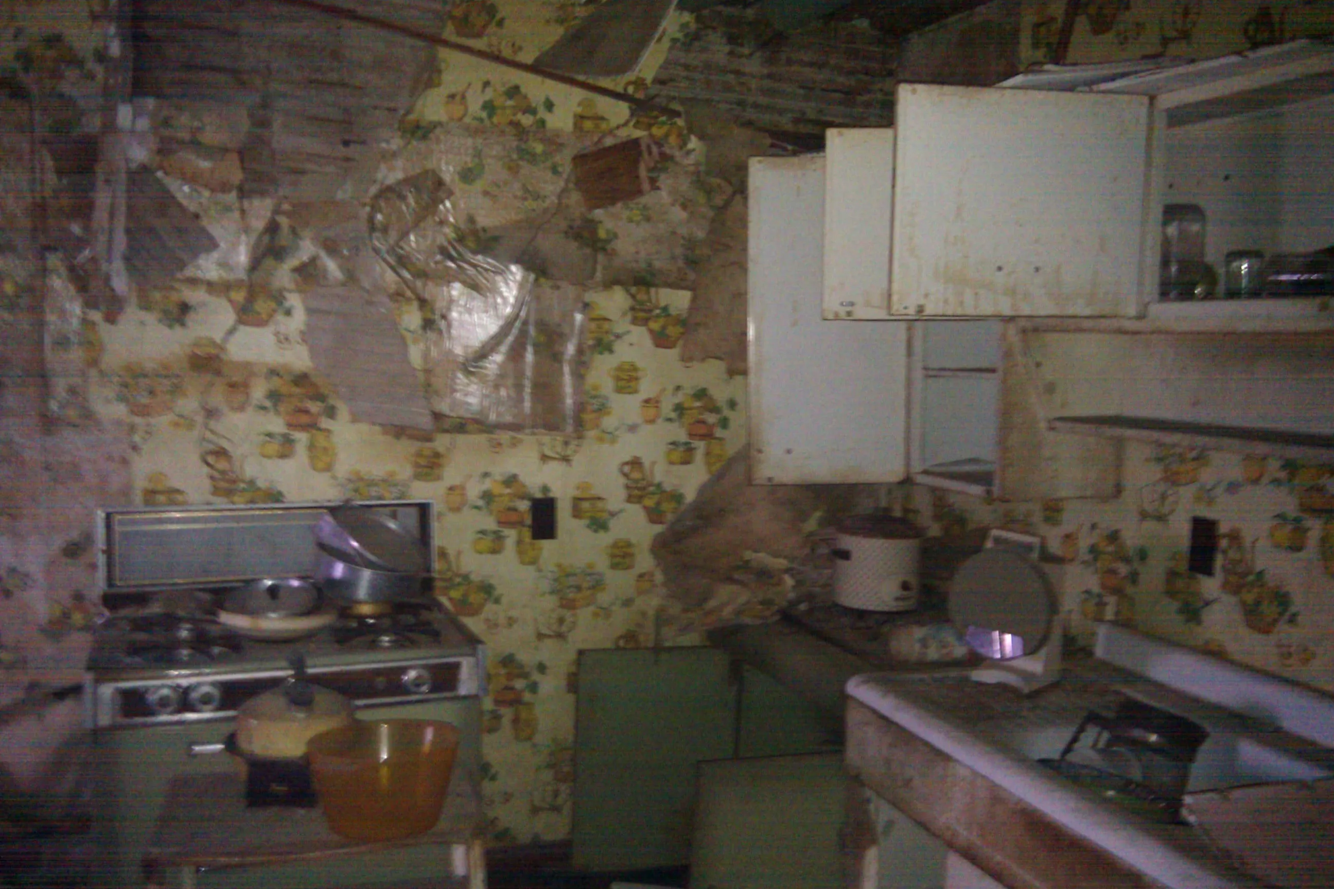 an abandoned house's kitchen filled with old appliances and dishes