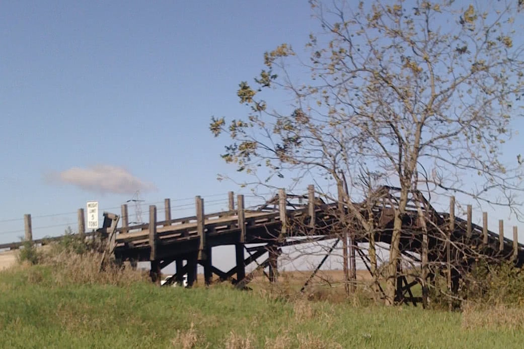 an all-wood bridge over a swampy area